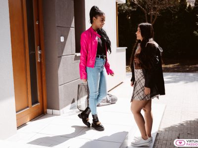 Two beautiful girls in fashionable clothes meet in the street for a date.