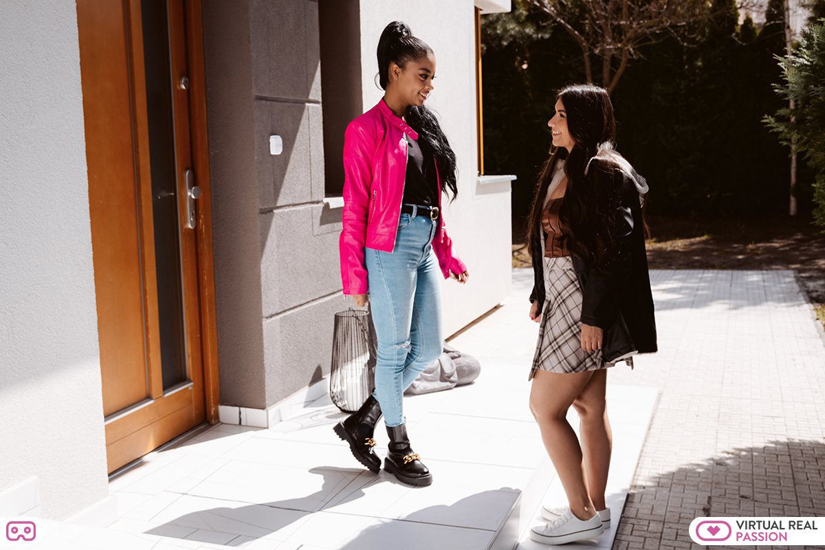 Two beautiful girls in fashionable clothes meet in the street for a date.